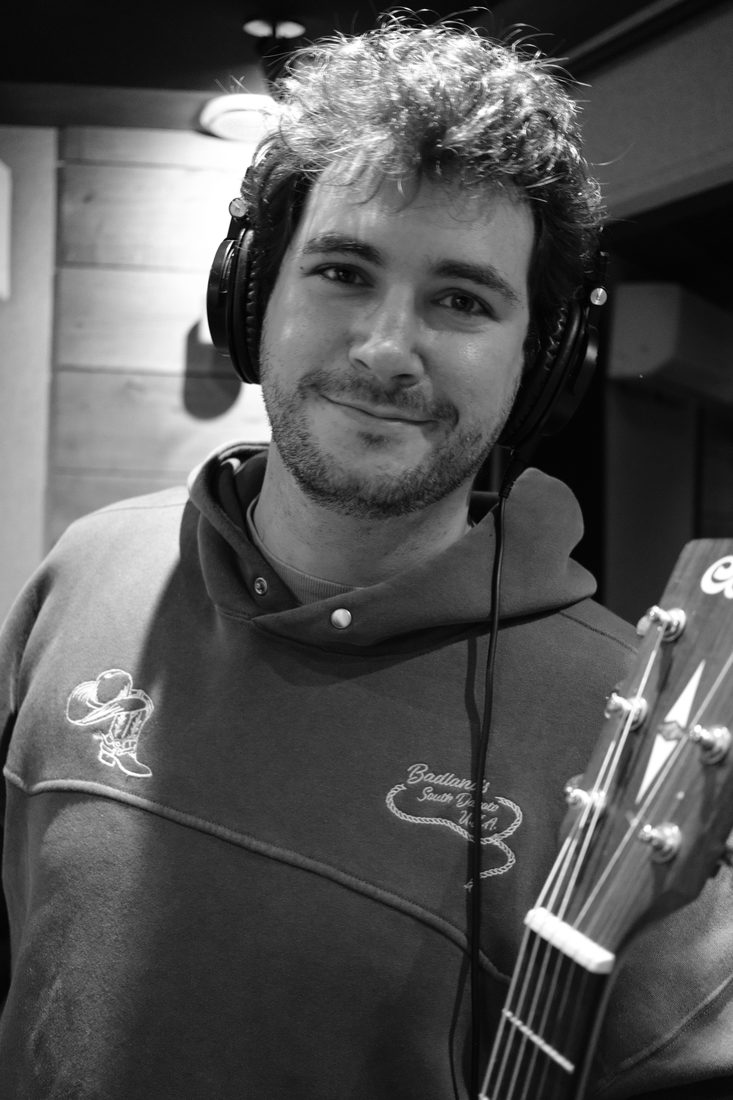 Côme en studio, casque sur les oreilles, souriant